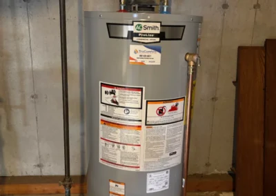 A gas water heater positioned in a garage, highlighting its functional design and surrounding storage items.